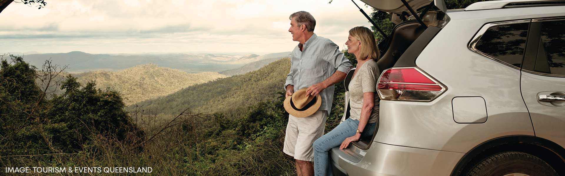 Couple in front of rental SUV in QLD