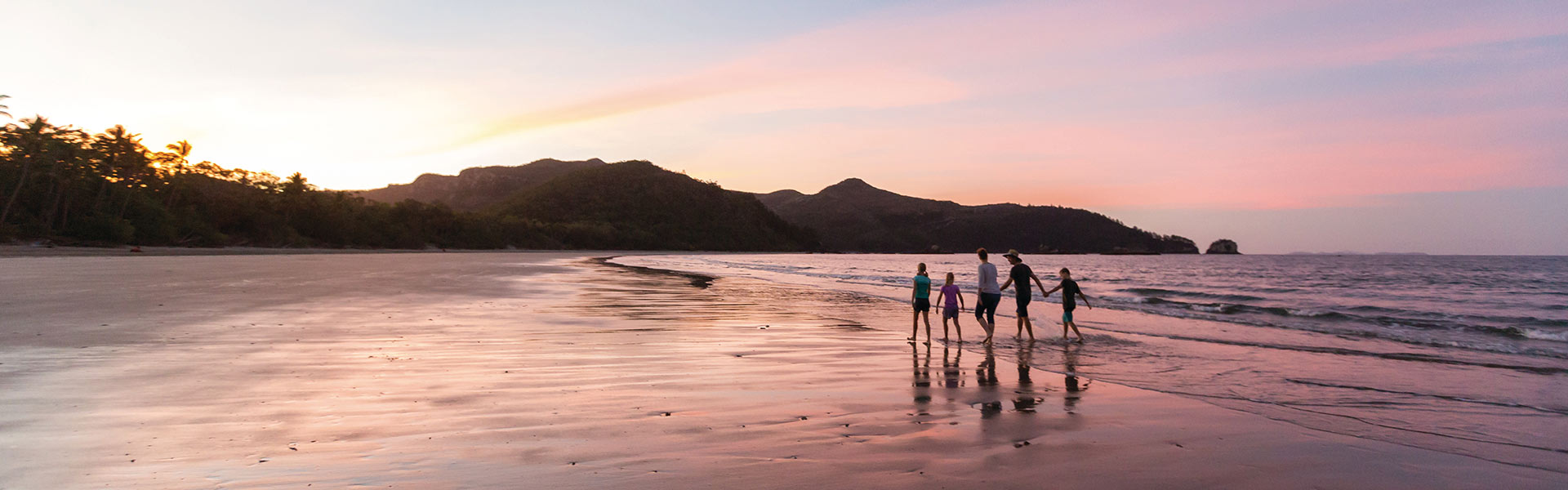 Family walking along Mackay beach